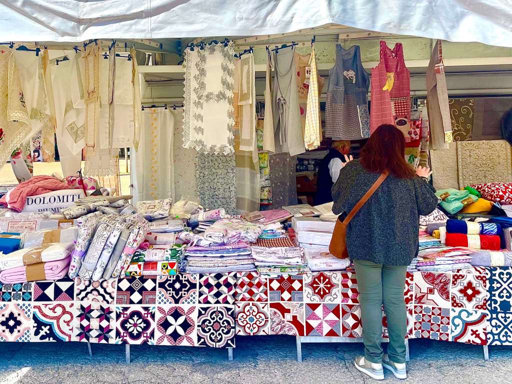Chiusi market in Tuscany with locals shopping for fresh produce, food stalls and traditional Italian market goods