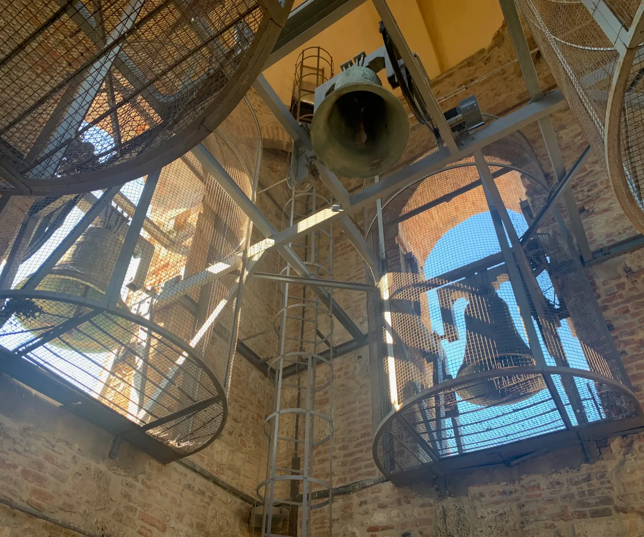 Historic bell tower in Chiusi, Tuscany, rising above terracotta rooftops with medieval and Etruscan heritage in view.