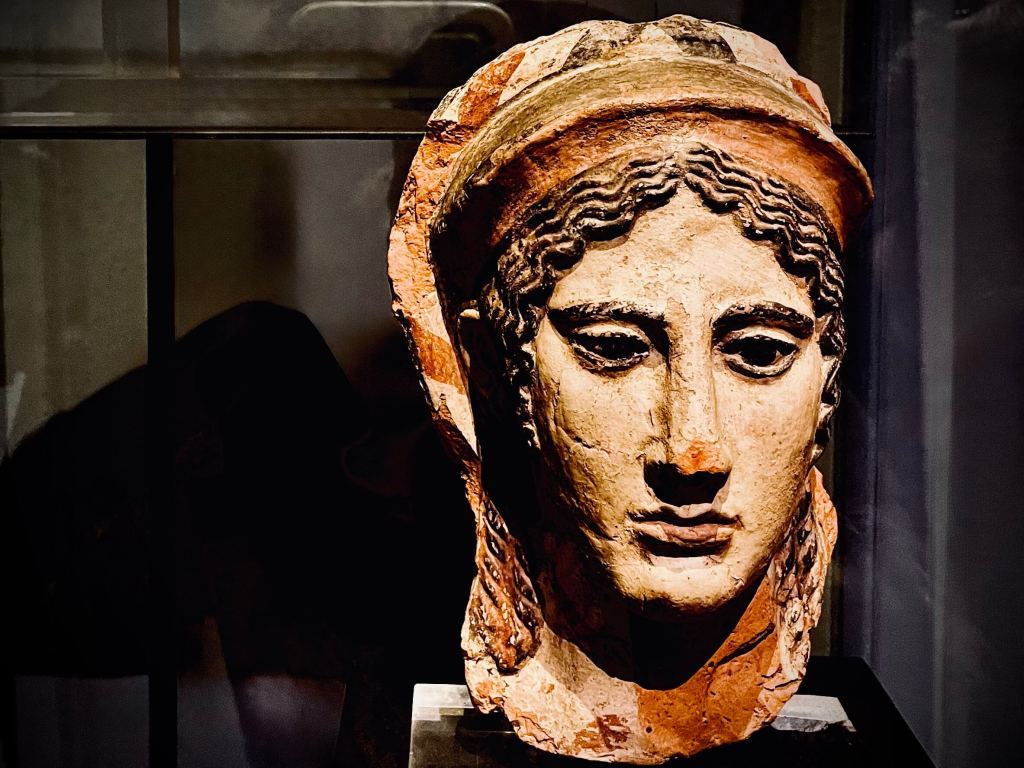 Ancient Etruscan bust of a woman from Chiusi museum, showing strong nose, almond-shaped eyes and softly modelled facial features in carved stone.