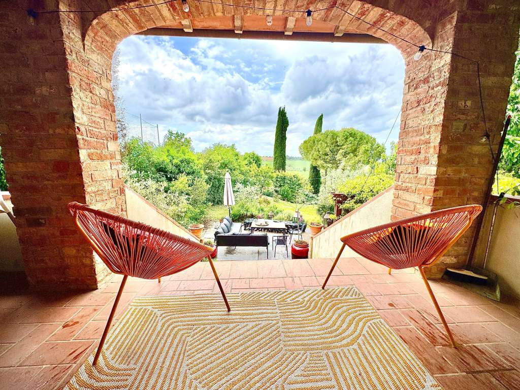 View from the balcony at Villa Gioiella overlooking the outdoor seating area, garden and surrounding Umbrian countryside