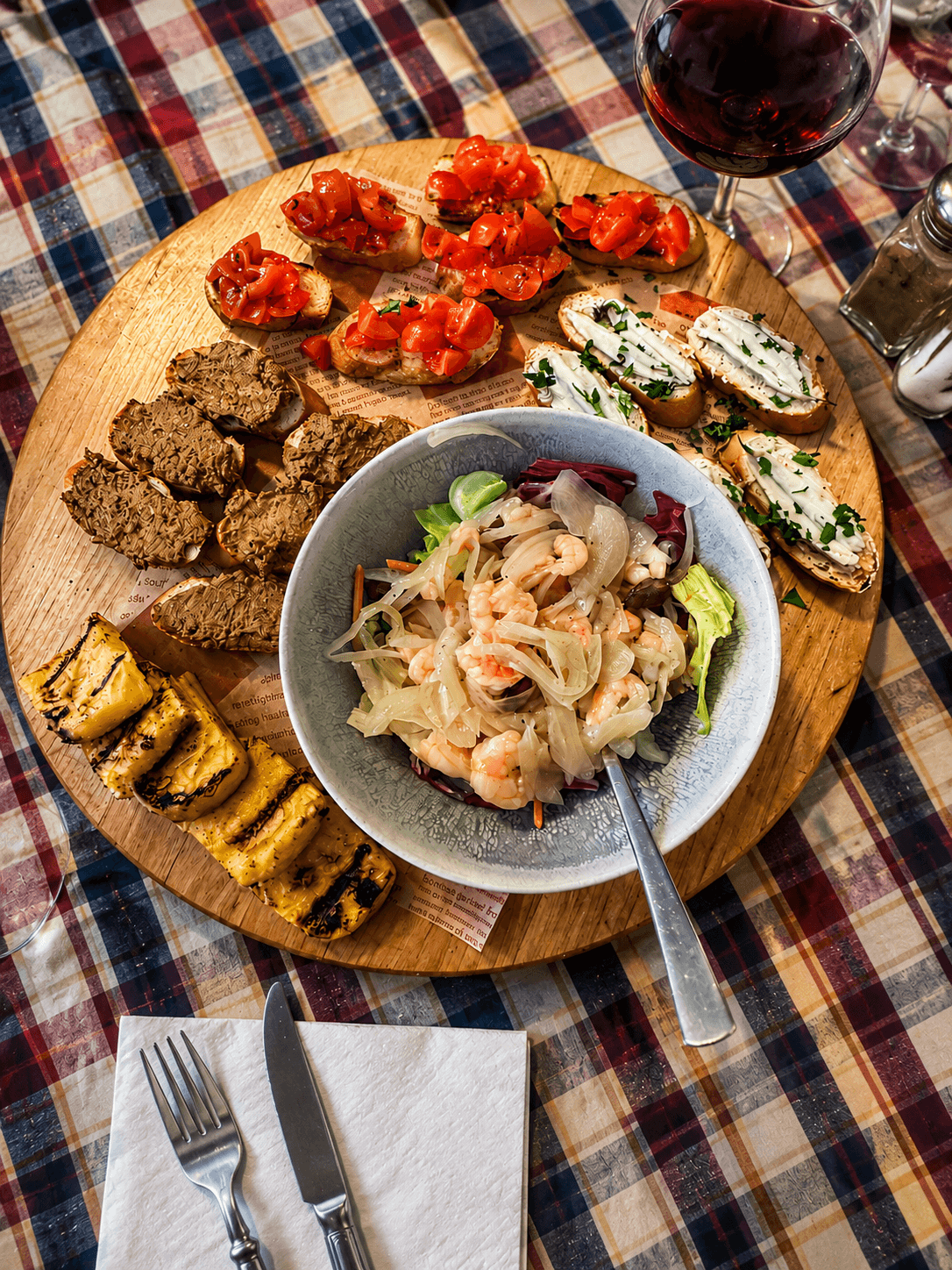 Italian antipasti sharing board prepared by Chef Jimmy at Villa Gioiella, featuring bruschetta, grilled vegetables, seafood salad, crostini and local wine.